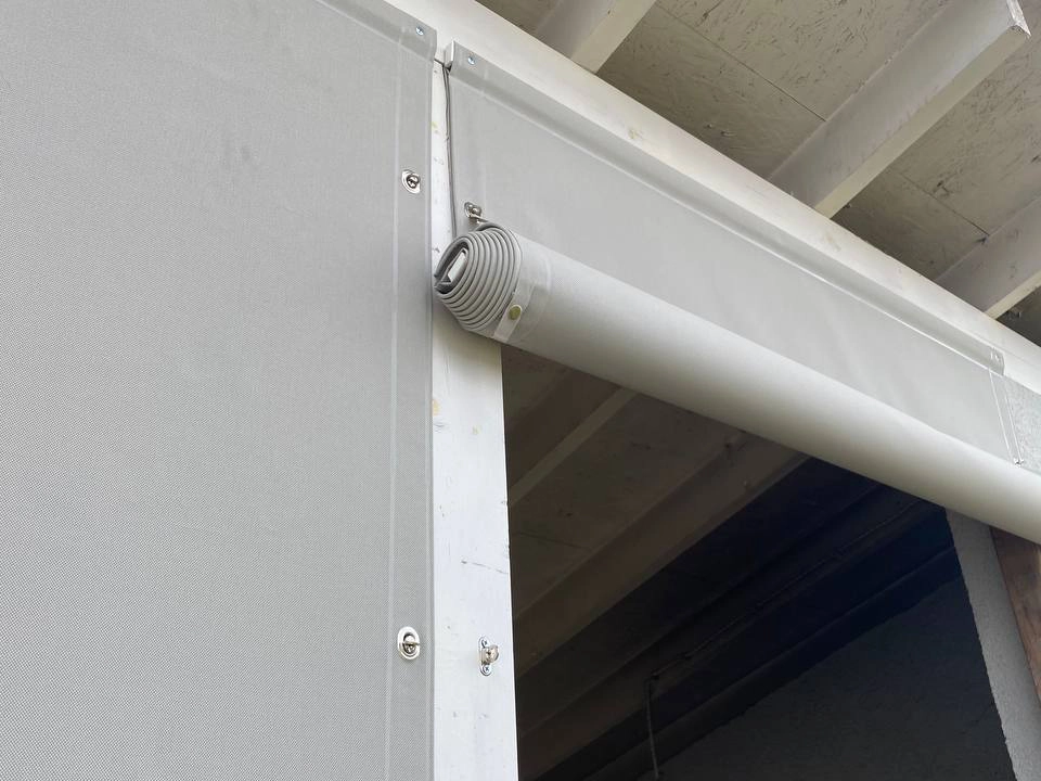 Светло-серые защитные шторы на беседке крупным планом